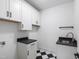 A laundry room featuring plenty of cabinet space, tile flooring, and modern sink at 617 Darian Woods Dr, Holly Springs, NC 27540