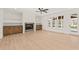 Bright, open living room features a fireplace with built-ins, a ceiling fan, and large windows at 617 Darian Woods Dr, Holly Springs, NC 27540