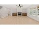 Bright living room featuring a fireplace, built-in shelving, ceiling fan and large windows at 617 Darian Woods Dr, Holly Springs, NC 27540