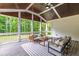 Screened-in porch with wood plank ceiling, outdoor furniture, and scenic wooded views at 617 Darian Woods Dr, Holly Springs, NC 27540