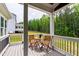 Covered porch features wooded view, black metal railing, with table and chairs at 617 Darian Woods Dr, Holly Springs, NC 27540