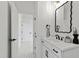 Stylish powder room features a modern mirror, black fixtures, and white vanity with decorative tile flooring at 617 Darian Woods Dr, Holly Springs, NC 27540