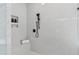 Modern shower with white marble tile, a built-in shelf, and a matte black shower head at 617 Darian Woods Dr, Holly Springs, NC 27540