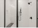 Close-up of a contemporary glass shower featuring black hardware and white tiled walls at 617 Darian Woods Dr, Holly Springs, NC 27540