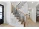 Elegant staircase featuring wood steps, modern black railings, and bright white wainscoting at 617 Darian Woods Dr, Holly Springs, NC 27540