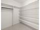 Bright walk-in closet with ample shelving and a hanging rod provides efficient storage solutions at 617 Darian Woods Dr, Holly Springs, NC 27540