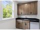 A stylish wet bar features sleek cabinetry, a mini-fridge, and a window offering serene views at 617 Darian Woods Dr, Holly Springs, NC 27540