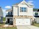 Charming two-story home featuring a stone facade, white siding, and an attached two-car garage at 63 Nimble Way # 183, Clayton, NC 27520
