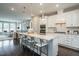 Open kitchen with white cabinets, center island, and seamless flow to living area at 2325 Bay Minette Sta # 548, Apex, NC 27502