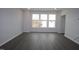 Bright, empty living room with dark vinyl flooring, white walls and trim, and recessed lights at 2325 Bay Minette Sta # 548, Apex, NC 27502