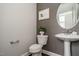 A stylish powder room features a pedestal sink, decorative mirror, and wallpapered accent wall, adding a touch of elegance at 2325 Bay Minette Sta # 548, Apex, NC 27502