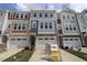 Townhomes with stone accents, garages, and coordinated color schemes line the driveways at 2325 Bay Minette Sta # 548, Apex, NC 27502