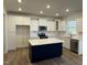 Modern kitchen with white cabinets and large island at 244 Combine Trl # Dm 108, Benson, NC 27504