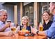 A group of adults share drinks and appetizers while socializing at an outdoor table at 252 Beacon Dr, Pittsboro, NC 27312