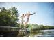 A father and son jump off the dock into the lake on a sunny day at 252 Beacon Dr, Pittsboro, NC 27312