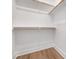 A clean, white closet provides ample storage space with wood-colored rods and light wood-style flooring at 324 Church St, Morrisville, NC 27560