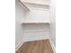 A bright, white closet has multiple wood-colored rods for storage and light wood-style flooring at 324 Church St, Morrisville, NC 27560
