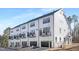 Modern townhome exterior showcasing white siding, black trim, individual balconies, and garage entrances at 324 Church St, Morrisville, NC 27560