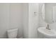 Powder room with a pedestal sink, oval mirror, and a white toilet set against a light gray wall at 622 Brittany Ct, Durham, NC 27703
