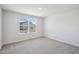 Bedroom featuring neutral carpeting, white walls, and a window with a view of a home in the neighborhood at 622 Brittany Ct, Durham, NC 27703