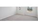 Bedroom featuring neutral carpeting, white walls, white trim, and windows offering a view of the neighborhood at 622 Brittany Ct, Durham, NC 27703
