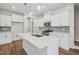 Modern kitchen featuring a center island, white cabinets, stainless steel appliances, and wood-look flooring at 622 Brittany Ct, Durham, NC 27703