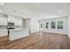 Open-concept kitchen and living area with white cabinets, an island, stainless steel appliances, and wood-look flooring at 622 Brittany Ct, Durham, NC 27703