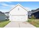 Two car garage with a driveway and landscaping, integrated seamlessly into the home's facade at 716 Georgias Landing Pkwy # 12, Raleigh, NC 27603