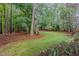 A verdant backyard features towering trees and a lush green lawn, perfect for outdoor activities at 1620 Dunn Rd, Raleigh, NC 27614
