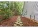 Backyard with a stone path and green space leading to a wooded area at 1620 Dunn Rd, Raleigh, NC 27614