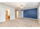 Large bedroom with blue accent wall, carpeting, and ensuite bathroom access at 1620 Dunn Rd, Raleigh, NC 27614