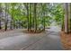 A paved driveway leads to a home with a two-car garage in a serene, wooded setting at 1620 Dunn Rd, Raleigh, NC 27614