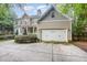 Spacious two-car garage featuring neutral siding and a concrete driveway surrounded by lush landscaping at 1620 Dunn Rd, Raleigh, NC 27614