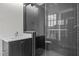 Bathroom with dark tile, a glass enclosed shower, and a bright white countertop at 2642 Marchmont St, Raleigh, NC 27608