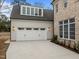 Spacious two-car garage with white doors, exterior lighting, and an upper level dormer at 2642 Marchmont St, Raleigh, NC 27608