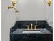 Stylish powder room with a unique black marble vanity and gold fixtures at 2642 Marchmont St, Raleigh, NC 27608