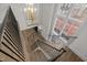 Grand staircase featuring hardwood steps, black iron railings, and a modern chandelier at 2642 Marchmont St, Raleigh, NC 27608
