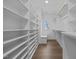 Spacious walk-in closet with built-in shelves, drawers, wooden floors, and natural light at 2642 Marchmont St, Raleigh, NC 27608