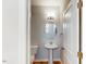 Powder room featuring a pedestal sink, oval mirror, modern lighting, and hardwood floors at 2729 Hunter Woods Dr # 568, Apex, NC 27502