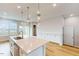Expansive island kitchen with a stainless steel sink, modern lighting, and abundant cabinet space at 2729 Hunter Woods Dr # 568, Apex, NC 27502