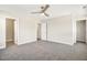 A spacious bedroom featuring carpet, neutral-toned walls, a ceiling fan, and several doors at 472 Traditions Grande Blvd # 34, Wake Forest, NC 27587