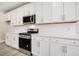 Close up of modern kitchen with white cabinets, countertops, and stainless steel oven at 472 Traditions Grande Blvd # 34, Wake Forest, NC 27587
