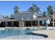 A community clubhouse with stone accents overlooks a sparkling pool, offering residents a perfect spot for relaxation at 472 Traditions Grande Blvd # 34, Wake Forest, NC 27587