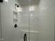 A sleek, modern shower with white tile, a glass door, and convenient built-in shelving at 476 Traditions Grande Blvd # 33, Wake Forest, NC 27587