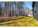 View of the backyard with a wooded area and a home partially visible in the background on a bright day at 109 Lone Star Dr, Louisburg, NC 27549