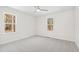 Bright bedroom features neutral carpet, two windows, and ceiling fan at 169 Running Deer Dr, Louisburg, NC 27549
