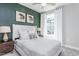 Cozy bedroom with a green accent wall and ample natural light at 2301 Beeblossom Pl, Fuquay Varina, NC 27526