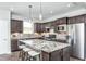Modern kitchen with granite island, stainless steel appliances, and dark cabinetry at 2301 Beeblossom Pl, Fuquay Varina, NC 27526