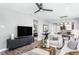 Spacious living room with large TV, comfy sofas, and ceiling fan at 2301 Beeblossom Pl, Fuquay Varina, NC 27526