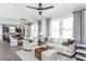 Bright living room with sectional sofa, coffee table, and large windows at 2301 Beeblossom Pl, Fuquay Varina, NC 27526